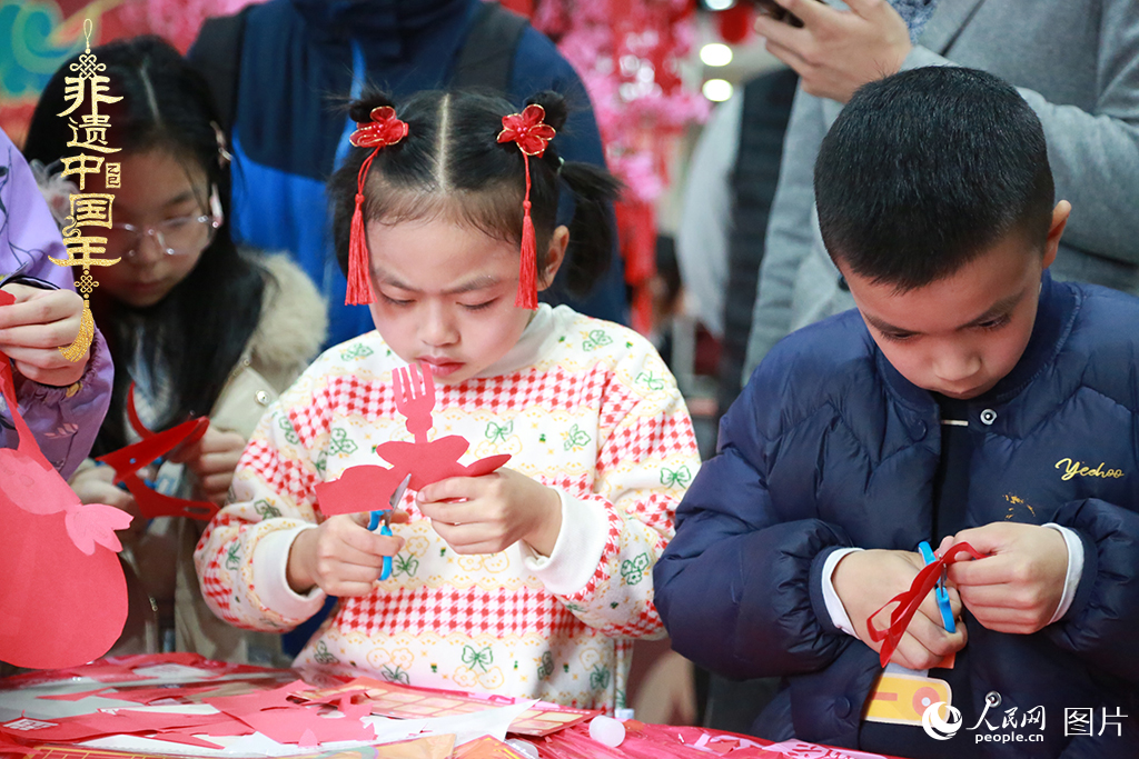 2025年1月23日，上海市青少年活動(dòng)中心迎新春游園會(huì)上，小朋友們正在學(xué)習(xí)剪窗花。人民網(wǎng)記者 龔莎攝