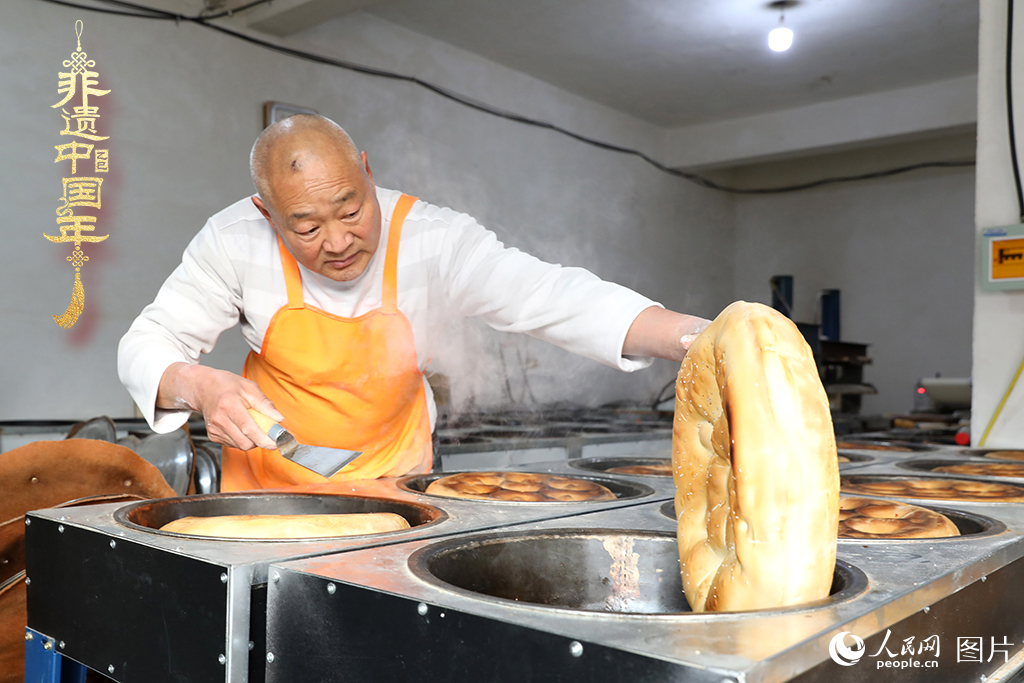 2025年1月23日，山東省臨沂市莒南縣一家傳統(tǒng)大餅作坊內(nèi)，師傅們正忙著烤制當(dāng)?shù)厝舜汗?jié)期間家家戶戶必備的、金黃誘人的莒南大餅。人民網(wǎng)記者 劉祺攝