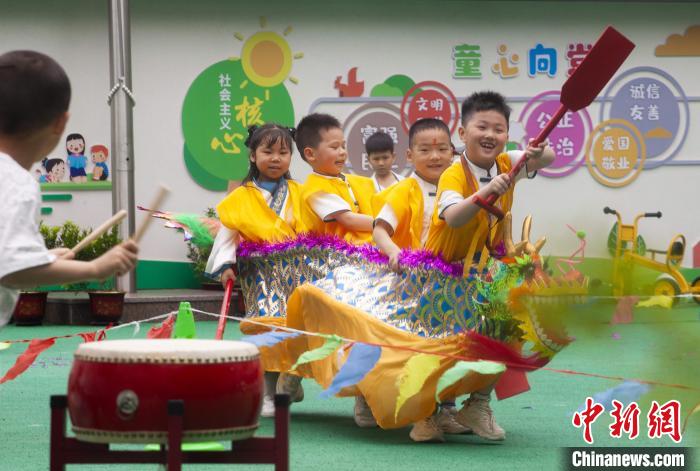 圖為龍舟賽游戲上，小伙伴們打鼓加油?！《^生 攝