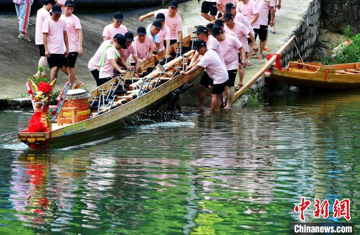 圖為5月29日，長(zhǎng)樂(lè)江田鎮(zhèn)村民們齊力推新龍舟下水。　張斌 攝