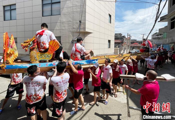 圖為5月29日，長(zhǎng)樂(lè)江田鎮(zhèn)村民們肩扛著新龍舟舉行入水前游街儀式?！埍?攝